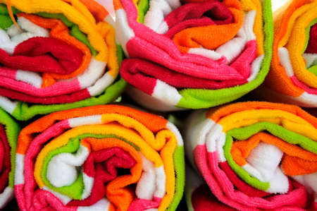 Multi-colored beach towels rolled up ready to use at the pool or beach.の写真素材