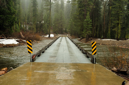 Steel constructed bridge provides a crossing over a small river in the El Dorado National forestの写真素材
