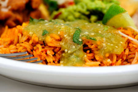 Spanish rice close-up with salsa verde made with tomatillo jalapeno garlic and cilantro poured over the topの写真素材