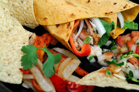 Spicy chicken wrap stuffed grilled meat, bell pepper, onions and cilantro with salsa and tortilla chipsの写真素材