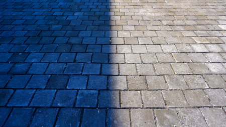 The Reflection Of A Dark And Bright Light On The Surface Of A Yard Made Of Gray Bricksの写真素材