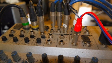 A Close-up Of A Vintage Audio Mixer, Showing The Various Cables Running Through It. The Image...