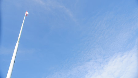 A White Flagpole Against A Bright Blue Sky, Photo Taken From Belowの写真素材