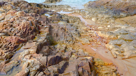 Aerial view of the rocky coastline on a clear day. Sheer cliffs, with textured surfaces and varying...