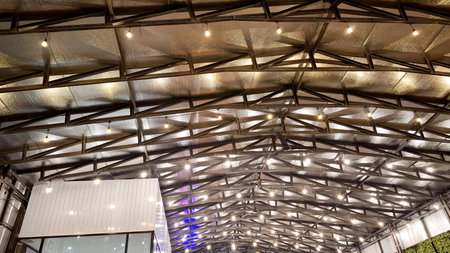 A wide low-angle view showing the intricate metal frame structure of a large interior space, perhaps a warehouse, factory, or event hall.の写真素材