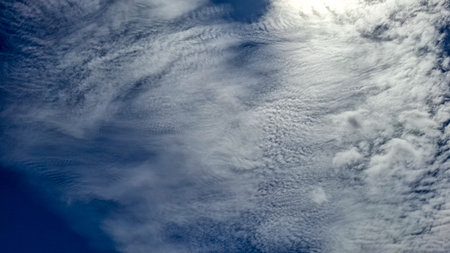A sweeping view of the sky with a stunning expanse of altocumulus clouds. The clouds display a...