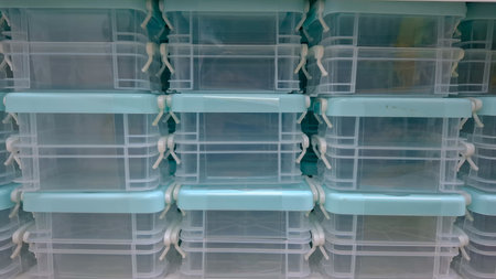 Close-up texture shot of a stacked collection of recycled rag rugs (chindi) dominated by cool color tones, including bands of navy blue, grey, white, and a slight accent of red.の写真素材