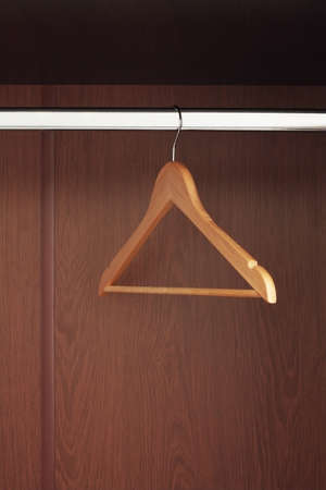Wooden hanger hanging in an empty closet on the upperの写真素材