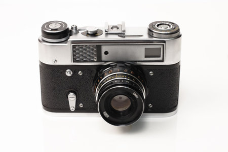 Old black silver camera on a white background