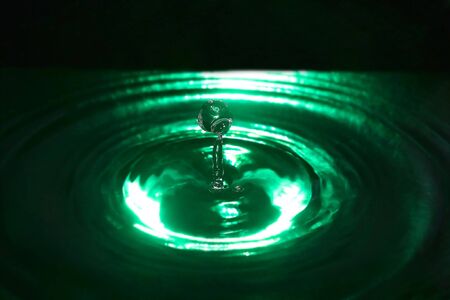 Abstract falling drops of water in dark green tonesの写真素材