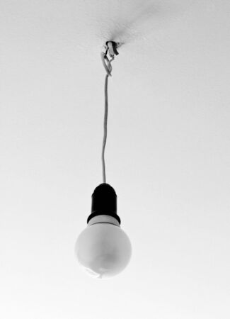 light bulb hanging from the ceiling in black and white colorsの写真素材