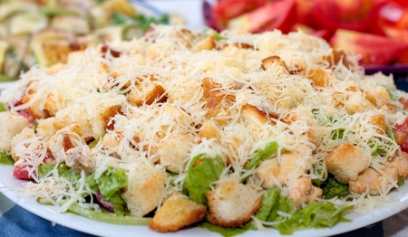 Caesar salad on a plate sprinkled with grated cheeseの写真素材