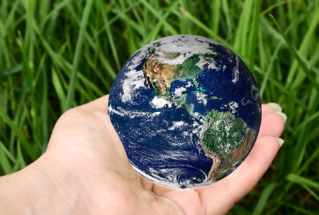 planet in hand on a background of grass の写真素材