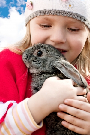 little girl holding a rabbit in her armsの写真素材