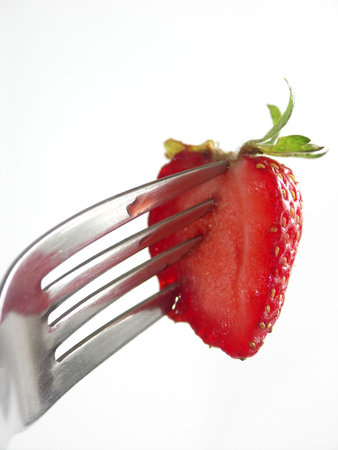 Strawberry colopuncture on fork on white backgroundの写真素材