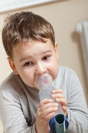 Close-up image little boy using inhaler for asthma.の写真素材