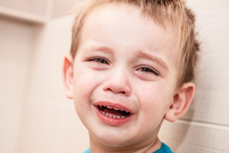 Portrait Of Crying Baby Boy In Home.