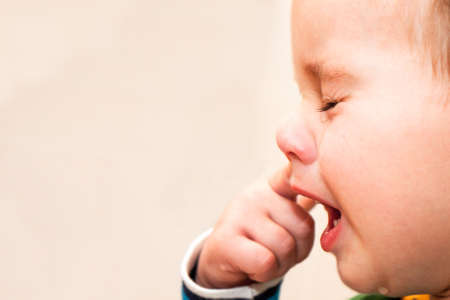 Portrait Of Crying Baby Boy In Home.の写真素材