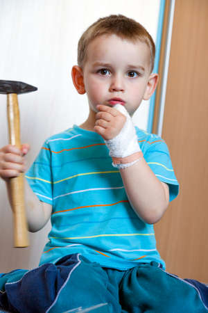 wounded in the left hand with bandage boy at shot in homeの写真素材