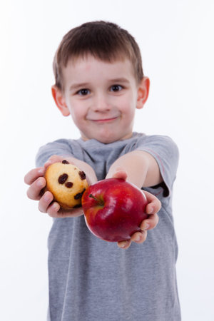 little boy with food isolated on white background - apple or a muffinの写真素材