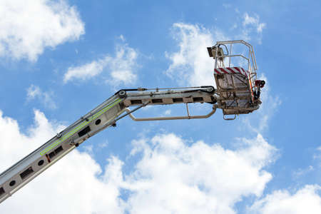 Fire truck ladder leading up into blue sky.の写真素材