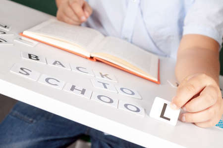 boy sitting at school desk with the inscription of the numbers back to schoolの写真素材