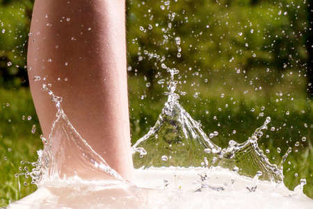 Little boy and splash of water in the summer garden - detail shotの写真素材