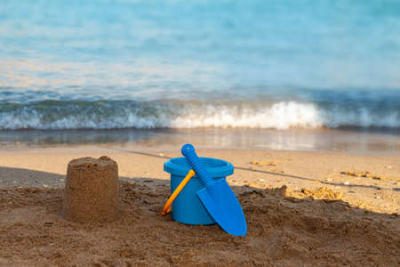 A person sitting on a sandy beach next to the oceanの写真素材