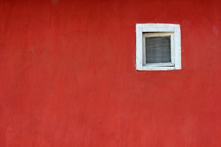 a white window on a red wall on the streetの写真素材