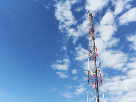 communication tower against partly cloudy blue skyの写真素材
