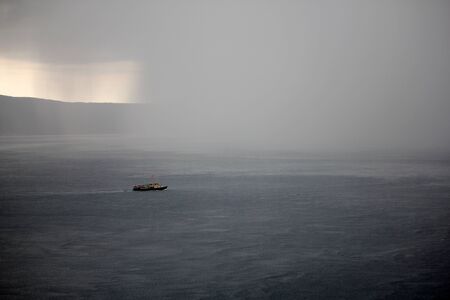 A summer storm hits a ship returning from the sea to portの写真素材