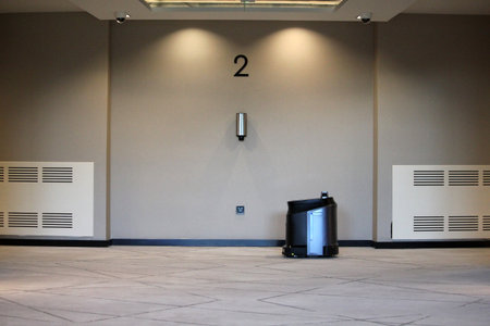 Robot vacuum cleaner working in the hotel corridor with no peopleの写真素材