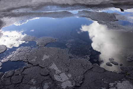 Reflection of Clouds in a Puddle in Parking Lot