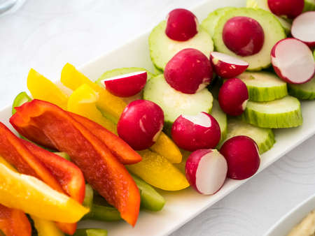 Close up of a plate with mixed fresh vegetables: redish, paprika, cucumberの写真素材