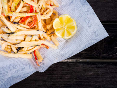 Overhead view of French fries and lemon on white servietteの写真素材