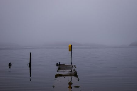 Lough Key in county Roscommon in Ireland foggy and flooded during winter with the swimming area submerged under waterの写真素材