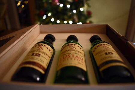 A selection of Redbreast Irish Whiskey in a box with a christmas tree in the backgroundの写真素材