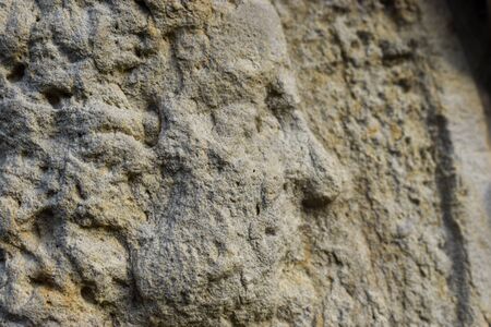 A close up view of a mans face in worn stone relief. Great for use as a concept representing history, mythology, architecture or european culture.の写真素材
