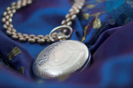 antique poket watch in blue vintage fabricの写真素材