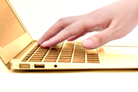Hand in the golden notebook computerの写真素材