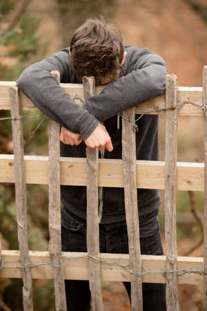 Teenage Boy Leaning On A Fenceの写真素材