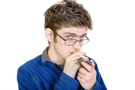 Teenage boy lighting a cigarette
