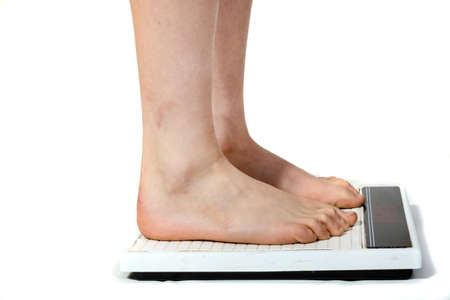 Feet standing on a scaleの写真素材