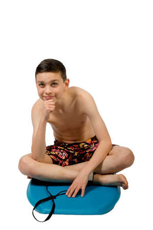 Teenage caucasian boy sitting on a body boardの写真素材