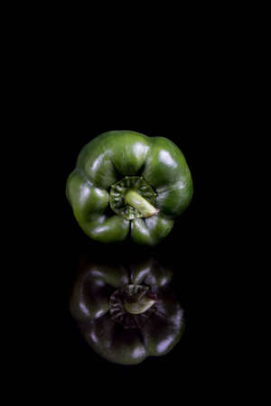 A single green sweet bell pepper with reflectionの写真素材