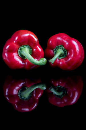 Two red sweet bell peppers with reflectionsの写真素材