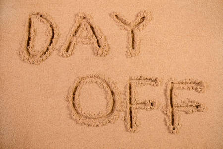 Day Off written in soft wet sand on a beachの写真素材