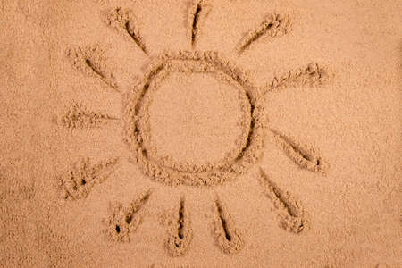 Sun drawn in soft wet sand on a beachの写真素材