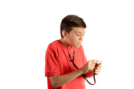 A young teenage boy isolated against white background playing with a stethoscopeの写真素材