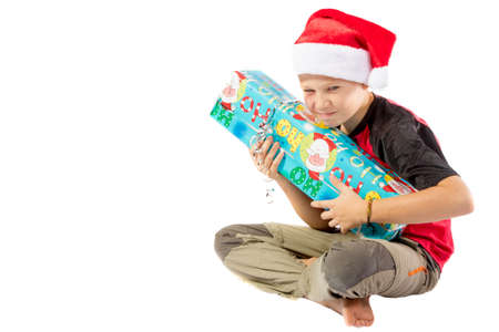 Sulky pre-teen boy with a christmas gift isolated on white backgroundの写真素材